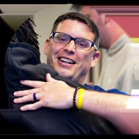 Tim Chiarolanza smiling as he hugs a supporter